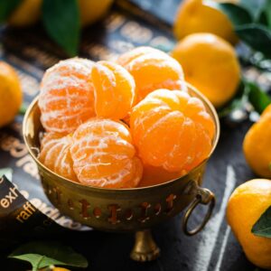 Vibrant peeled and whole tangerines in a rustic bowl highlighting freshness and health.