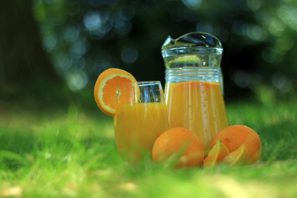 A vibrant outdoor setting featuring fresh orange juice with sliced oranges, perfect for a refreshing drink.